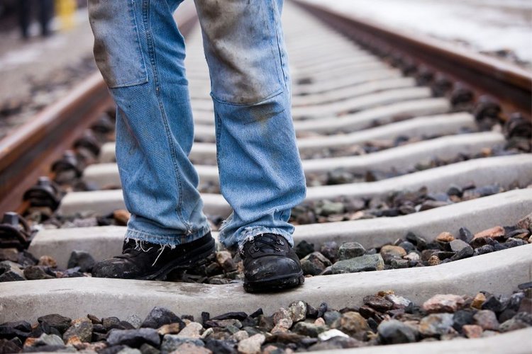 Man wear jeans working on the train tracks