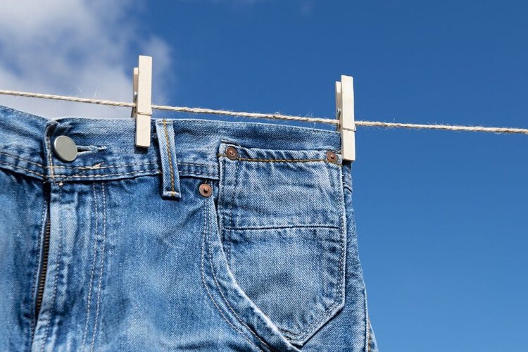 hang jeans on clothesline in the sun to dry it