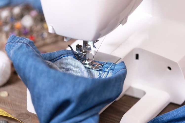 a person takes up the hem of jeans