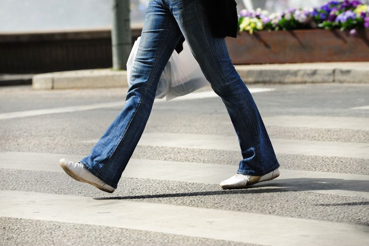 a person with jeans walks on the street