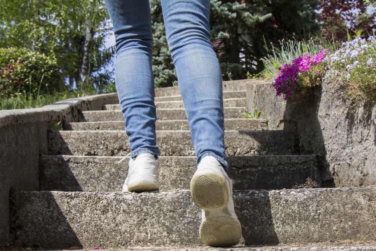 a woman in jeans is walking up stairs