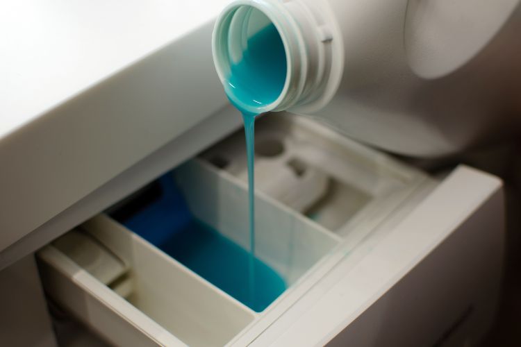 pour color-safe detergent for jeans in washing machine drawer