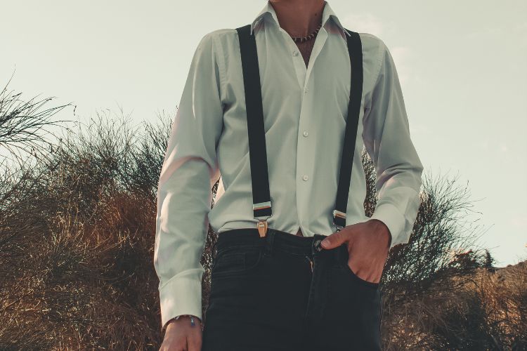 a man wears suspenders with jeans