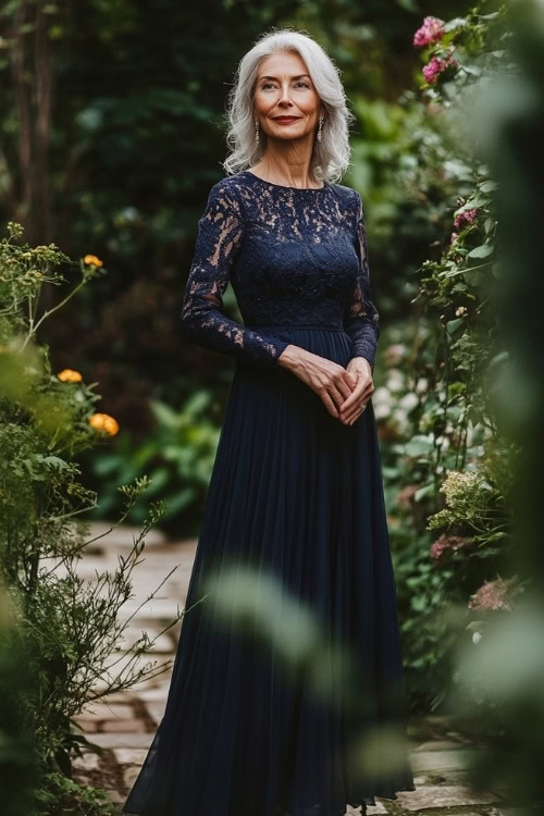 A full-body view of a woman over 50 wearing an elegant navy-blue midi dress with long lace sleeves, standing in a garden setting (2)