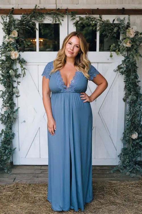 A plus size woman wearing a lace-trimmed dusty blue maxi dress with a smocked bodice and short sleeves