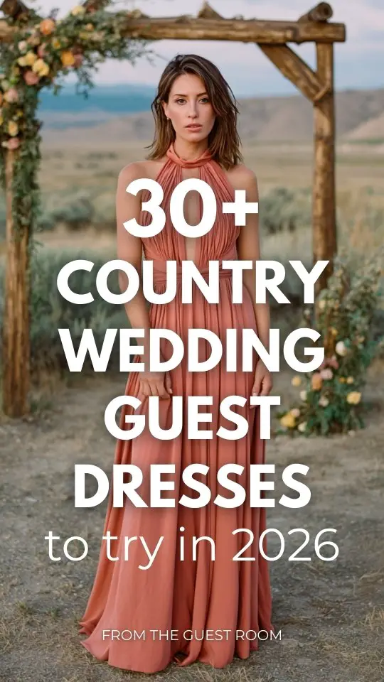 A woman in a muted coral halter-neck country wedding guest dress with a keyhole cutout and pleated skirt