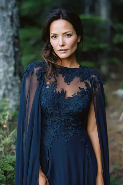 A woman over 30 wears a high-low navy chiffon dress with lace appliqué and a sheer cape train
