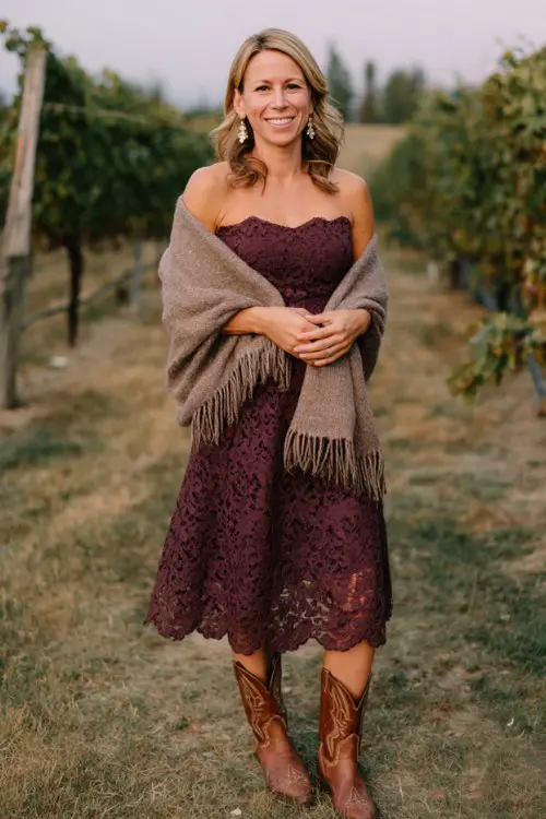 a woman wears a burgundy wedding guest dress with cowboy boots