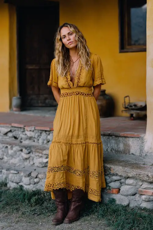 A woman over 30 wears a goldenrod boho-style maxi dress with crochet trim and chocolate brown slouchy boots