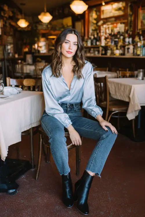 A relaxed yet polished date night outfit featuring straight-leg jeans, a silky blouse, and classic ankle boots