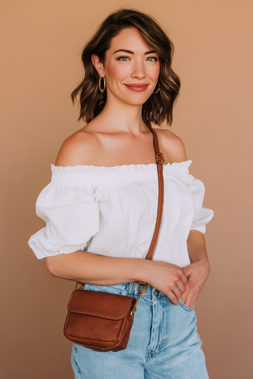 a woman wears a white blouse and jeans with a brown bag