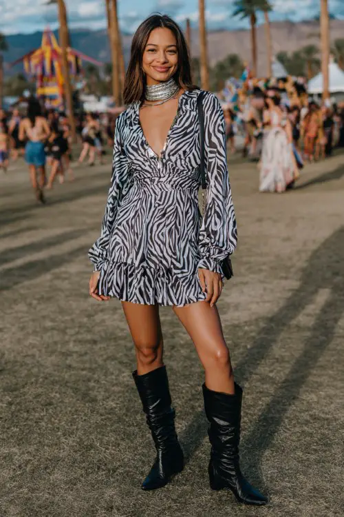 a woman wears a long-sleeve zebra print mini dress with a fitted waist and slightly flared skirt, paired with sleek black knee-high heeled boots