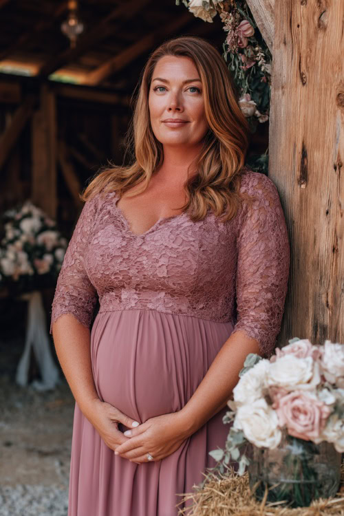 A plus-size woman over 50 in a dusty rose A-line dress with lace three-quarter sleeves and a modest scoop neckline, standing beside a rustic wooden wedding ceremony setup 