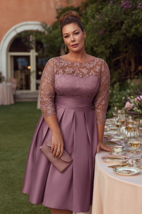 A plus-size woman over 50 wearing a mauve midi-length fit-and-flare dress with lace sleeves and a matching clutch, standing by a garden reception table set with fine china