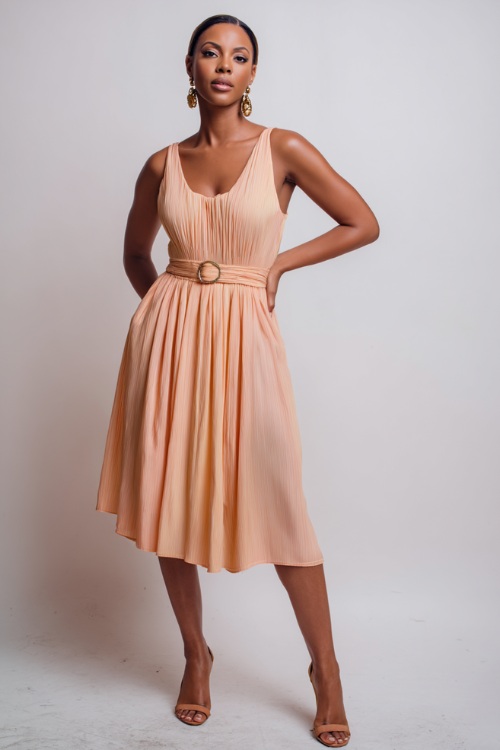 Elegant lady wearing a soft pastel peach sleeveless pleated midi dress with vintage-style earrings, posing confidently in a high-end studio with a clean white backdrop
