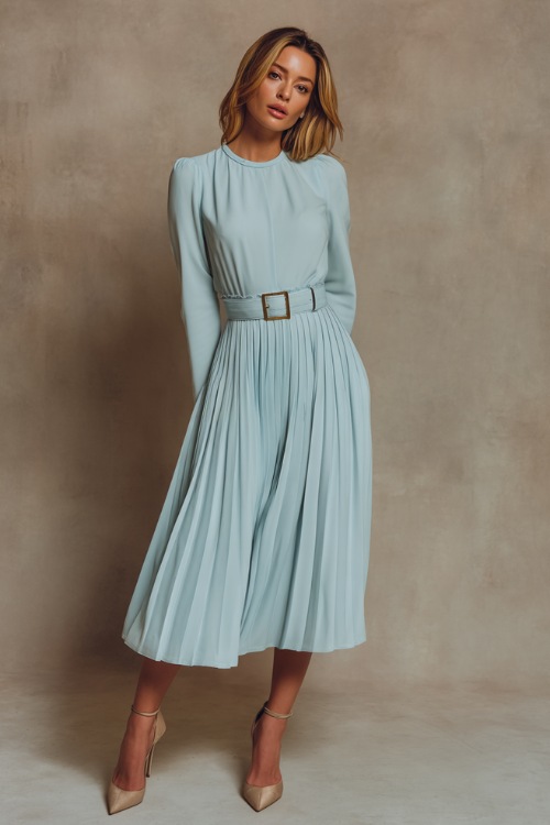 Elegant woman wearing a light blue sleeveless midi dress with pleated skirt and a thin belt, posing gracefully against a soft taupe studio backdrop 