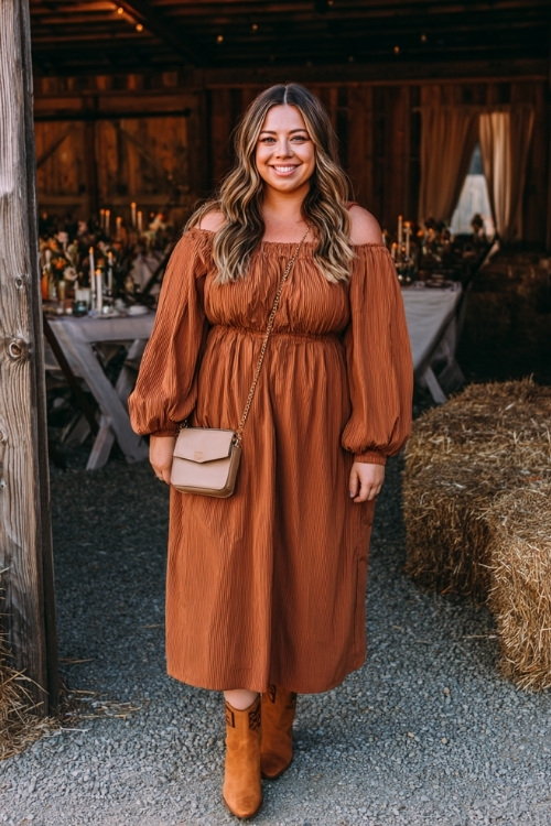 Full body of a plus-size woman wearing a cinnamon brown midi dress with smocked bodice and long balloon sleeves, paired with tan ankle boots and a crossbody bag 
