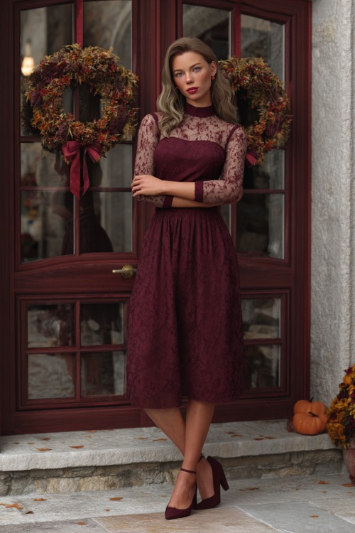 Full body of a woman wearing a maroon A-line midi wedding guest dress with sheer lace long sleeves and low heels 