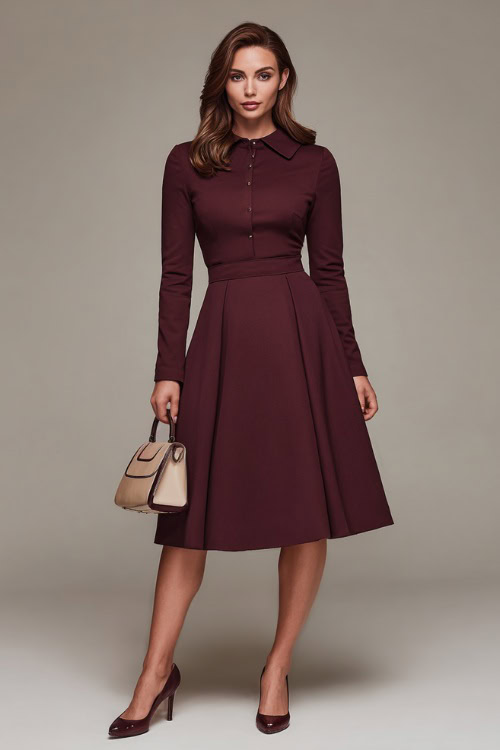 Full-body shot of a woman in a burgundy A-line dress with long sleeves and a modest collar, accessorized with a mini top-handle bag and classic pumps 