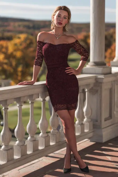 A woman in a burgundy lace knee-length dress with illusion sleeves, accessorized with pearl earrings and black heels