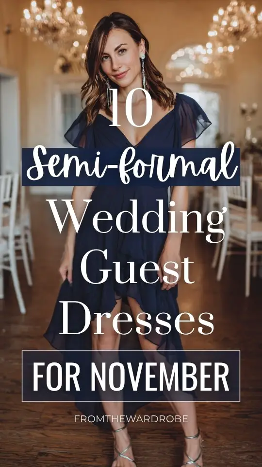A woman wears a navy chiffon high-low fall wedding guest dress, styled with silver strappy sandals and drop earrings for a semi-formal November wedding