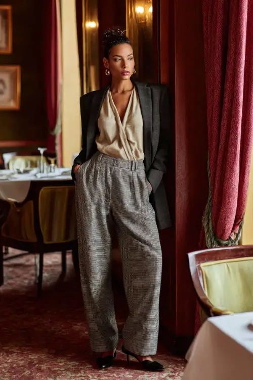 A woman dressed in wide-leg wool trousers paired with a cashmere knit top and a structured blazer, styled with loafers or low heels 
