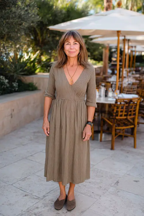 A woman over 50 wearing a casual midi dress with three-quarter sleeves, styled with comfortable flats and minimal jewelry