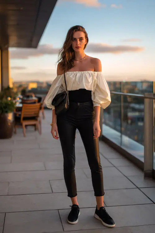 A fashionable woman wearing black skinny jeans, off-shoulder blouse, sleek leather sneakers, structured mini bag, rooftop dinner background, full-body editorial photo
