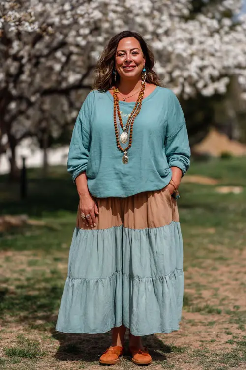 A plus-size woman over 40 wears a spring comfy boho look with a soft knit top and a tiered midi skirt