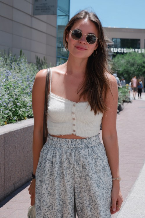 a woman wears a chic boho outfit with a white ribbed top and boho pants