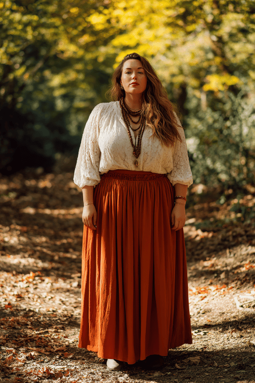 a plus-size woman wearing a flowing rust-orange maxi skirt paired with a cream lace peasant blouse, layered wooden bead necklaces, and ankle boots