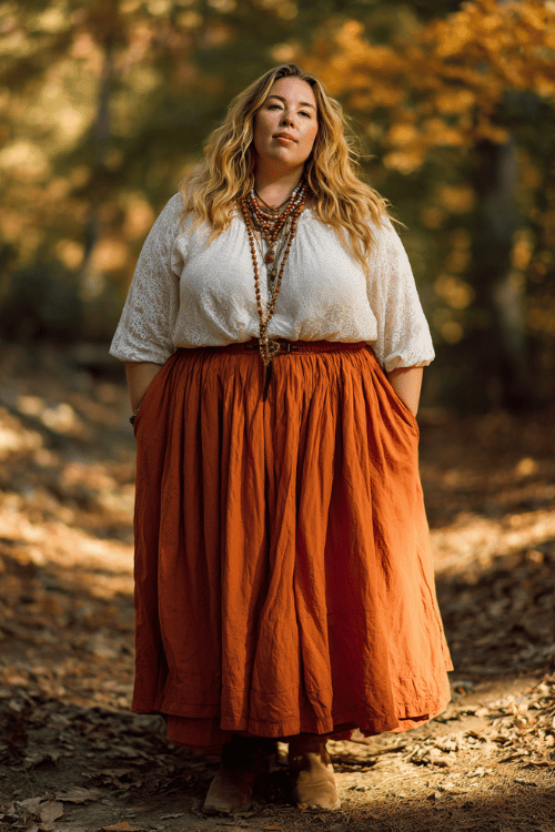 a plus-size woman wearing a flowing rust-orange maxi skirt paired with a cream lace peasant blouse, layered wooden bead necklaces, and ankle boots