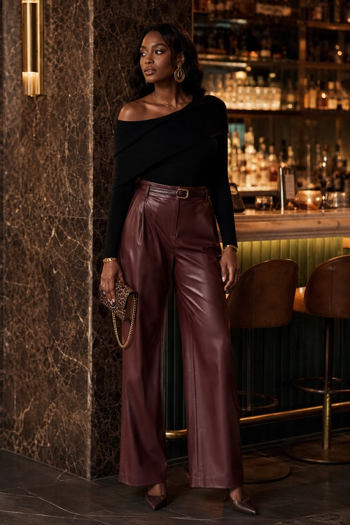 Black Top and Burgundy Trousers A woman wears a black off-shoulder long-sleeve top with burgundy wide-leg leather trousers, pointed heels, gold jewelry, and a small patterned clutch.
