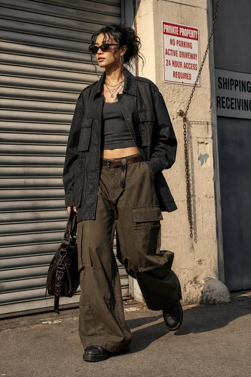 Black Utility Jacket with Olive Cargo Pants Street style outfit featuring a black utility jacket, cropped black top, olive cargo pants, sunglasses, and a black shoulder bag.