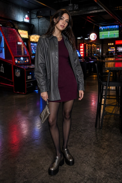 A burgundy mini dress styled with a charcoal leather-look jacket, sheer black tights, chunky black platform shoes, and a small metallic bag.