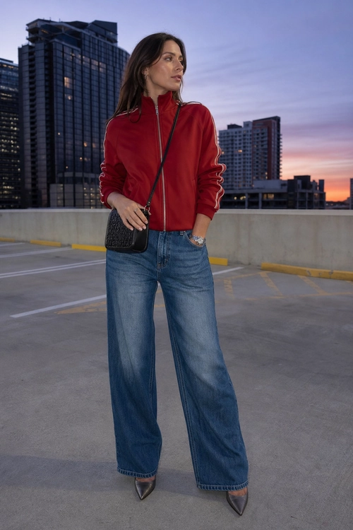 Red Track Jacket with Wide-Leg Jeans A red zip-front track jacket styled with wide-leg blue jeans, a black crossbody bag, and pointed dark shoes.