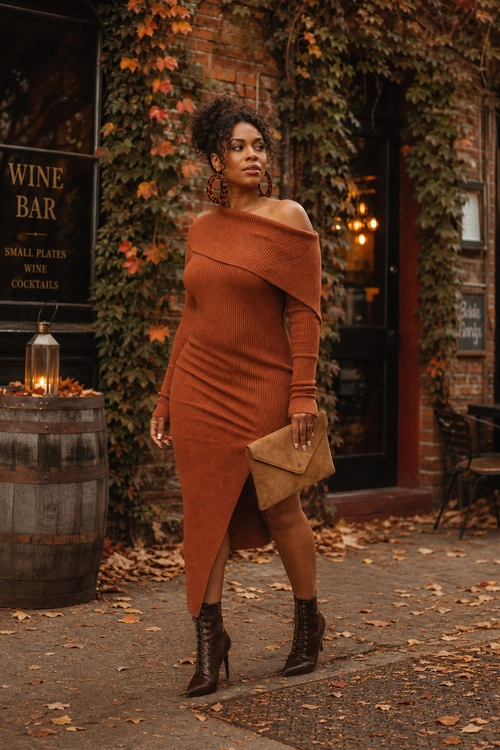 Rust Off-Shoulder Knit Dress A woman wears a rust off-shoulder ribbed knit midi dress with dark heeled ankle boots, statement earrings, and a tan clutch.