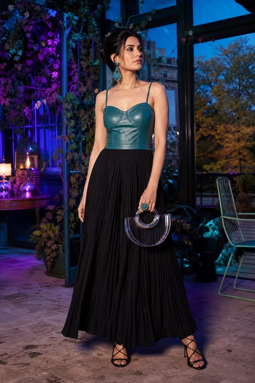 Teal Top and Black Pleated Skirt A woman wears a teal fitted camisole top with a black pleated maxi skirt, strappy heels, turquoise earrings, and a transparent circular-handle handbag.