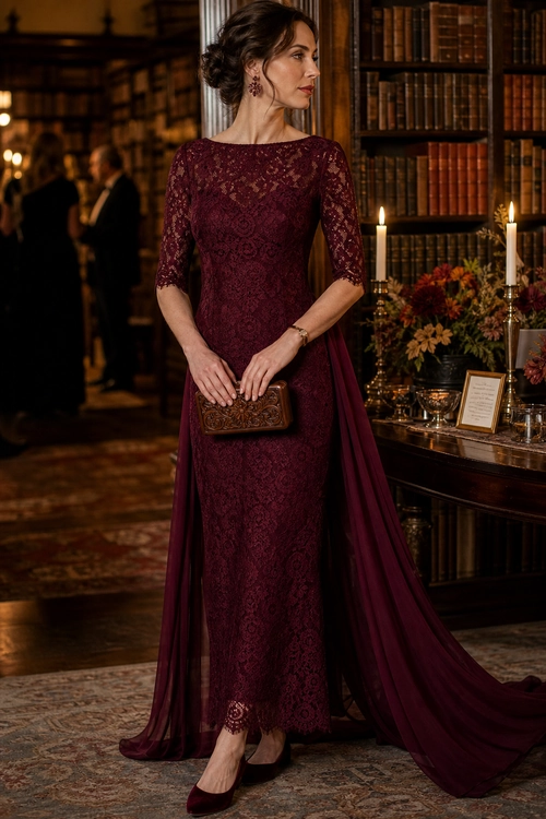 A woman wearing a burgundy lace floor-length gown with trailing draped panels, matching pumps, and an ornate clutch.