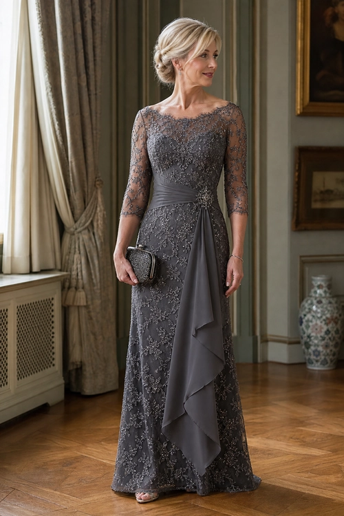 A woman wears a floor-length charcoal gray lace gown with sheer three-quarter sleeves, a draped waist detail, and a small metallic clutch.