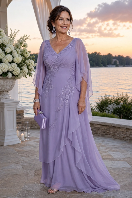 A woman wears a floor-length lavender gown with floral embellishments, sheer draped sleeves, a matching clutch, and metallic sandals.