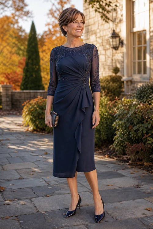Woman wearing a navy midi dress with lace three-quarter sleeves, draped detailing, pointed pumps, and a small clutch.