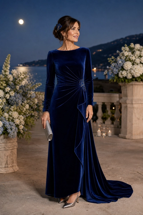 Navy Velvet Evening Gown A woman wears a floor-length navy velvet gown with long sleeves, a draped train, silver heels, and a silver clutch.