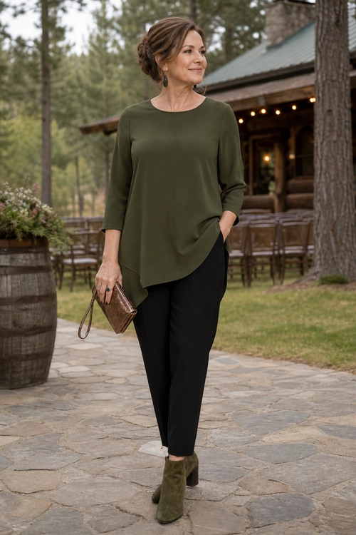 Olive Blouse and Black Trousers Outfit Woman wearing an olive long-sleeve blouse with black trousers, olive ankle boots, and a brown clutch.