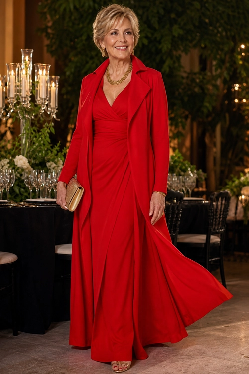 Red Gown with Tailored Blazer Woman wearing a flowing red floor-length gown with a tailored red blazer, layered gold necklace, gold clutch, and open-toe sandals.