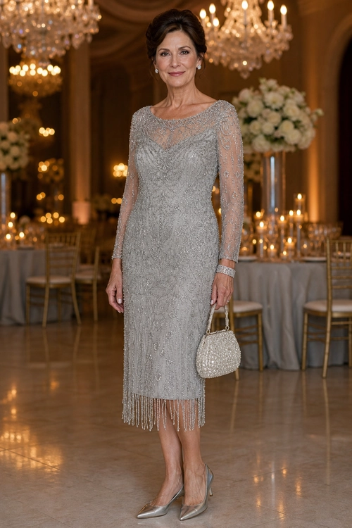 A woman wears a silver-gray beaded midi dress with sheer long sleeves, fringe hem, a beaded handbag, and metallic pointed-toe pumps.