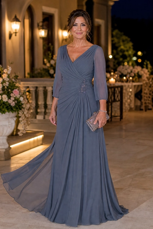 A woman wears a slate blue floor-length gown with a draped V-neck bodice, sheer three-quarter sleeves, and a trailing skirt.