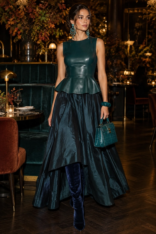 Teal Leather Peplum Evening Outfit A sleeveless teal leather peplum top styled with a long glossy dark skirt, navy velvet boots, and a teal textured handbag.